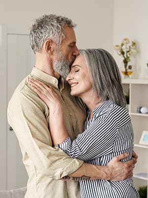 A grey haired mature couple hugging each other
